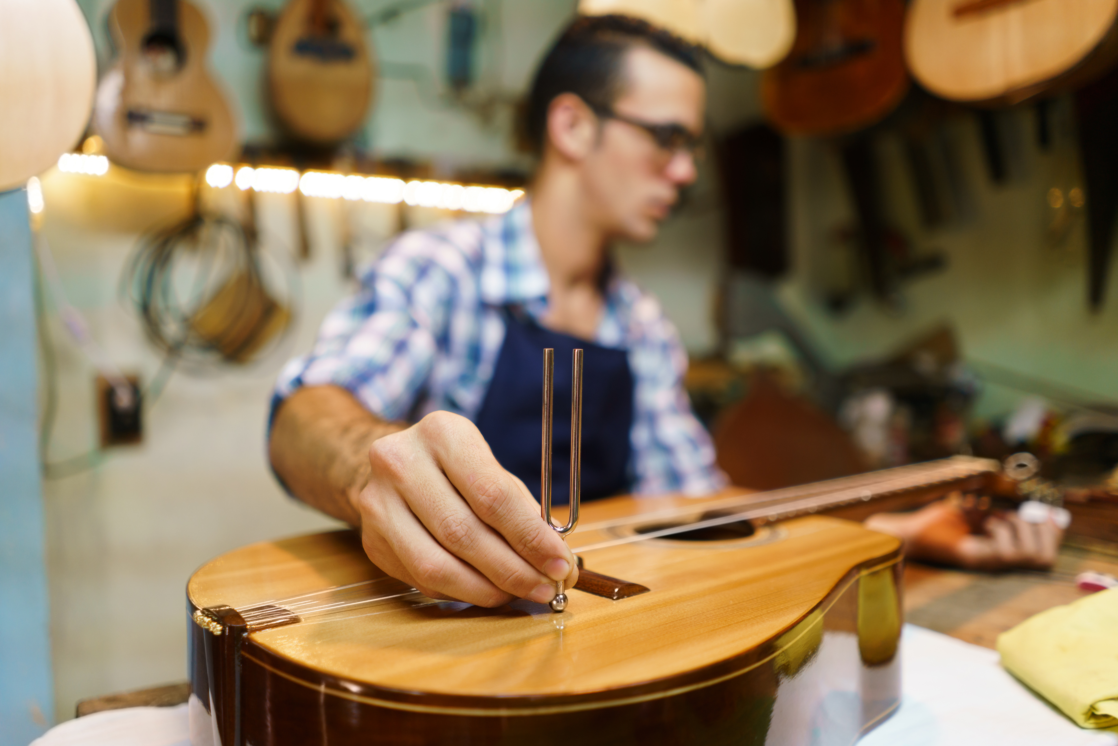 a guy tuning a guitar